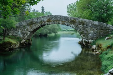 Fototapeta na wymiar Ancient stone bridge over a serene river