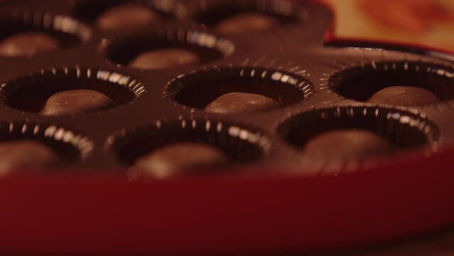 A heart shaped box of chocolates being set down and opened