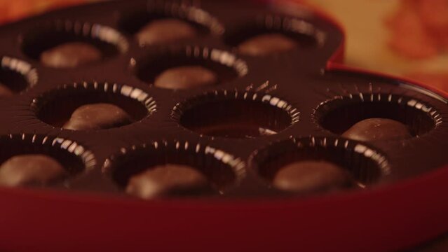 A heart shaped box of chocolates being set down and opened