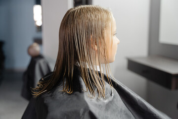 Young boy getting a haircut from a barber in a barbershop