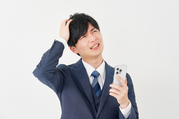 スマートフォンを持って頭を抱えるビジネスマン　白背景
