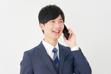 スマートフォンで通話するビジネスマン　白背景