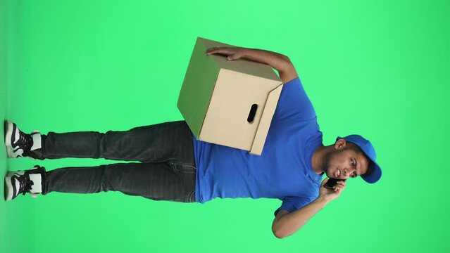 A man on a green background with box conversate on the phone