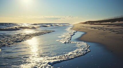  a view of a beach with waves coming in to the shore and the sun shining on the sand and water.