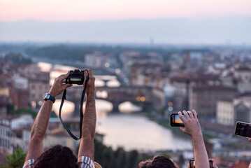 Large tourist crowd on Piazzale Michelangelo enjoying sunset over Florence