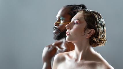 Gender equality concept. Gay male and female wearing make up close up portrait side view isolated...
