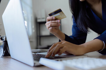 Young woman makes a purchase on the Internet on the laptop with credit card