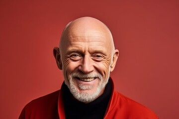 Portrait of a smiling senior man in a red jacket. Studio shot.