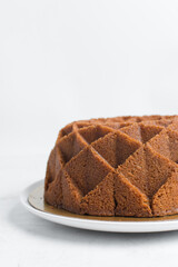 Vanilla bundt cake on a white plate, homemade bundt cake on a white background