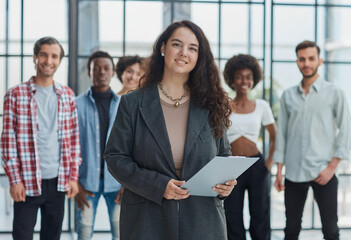 business woman with her staff in background at office