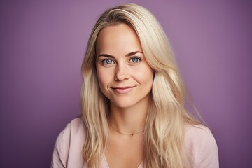 Portrait of a beautiful young blonde woman on a purple background.