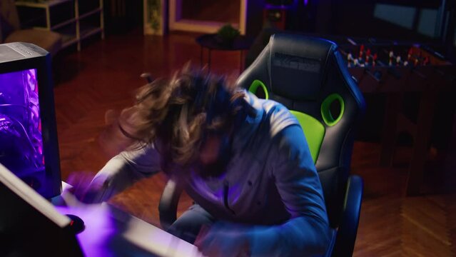 Angry gamer raging after losing against opponent in online esports competition. Upset player smashing keyboard on his head after being defeated by enemy in videogame internet tournament