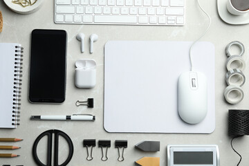 Flat lay composition with wired computer mouse and stationery on light grey table. Space for text