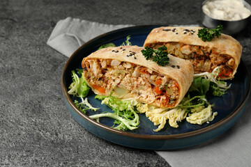 Pieces of delicious strudel with chicken and vegetables served on grey textured table, closeup