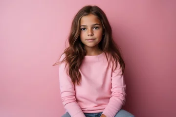 Tuinposter Portrait of a cute little girl in a pink sweater on a pink background © Chacmool