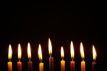 Hanukkah celebration. Burning candles on black background