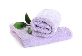 Obraz na płótnie Canvas Violet terry towels and green leaves isolated on white