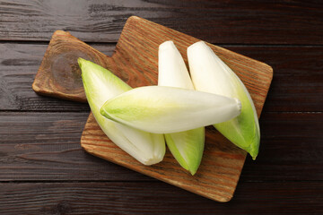Raw ripe chicories on wooden table, top view