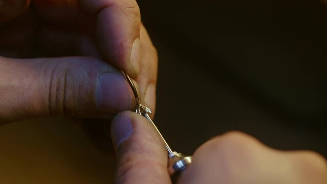 Close-up footage: Jeweler intricately carving a setting for a precious gemstone in a ring.