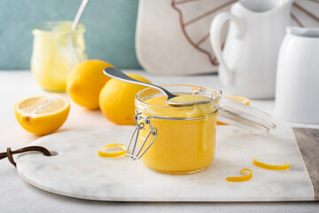 Lemon curd in a jar with fresh lemons, homemade dessert or topping idea