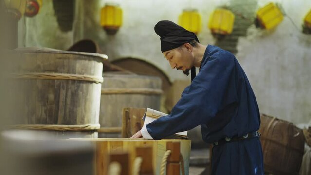 people in ancient costume making rice wine with book