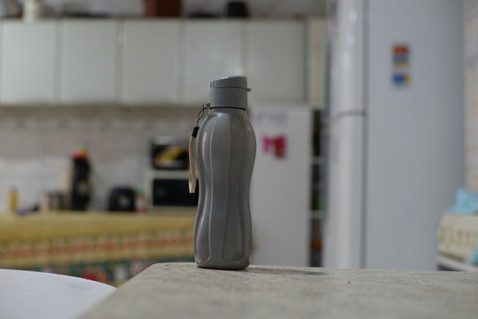 Garrafa térmica cinza na cozinha, garrafa de agua cinza, garrafa de plástico cinza