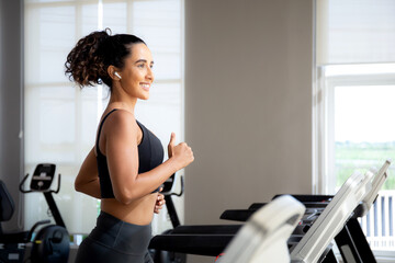 Fototapeta premium Young woman workout with jogging and exercise on machine treadmill in fitness gym sport, woman exercise with cardio training jogging, healthcare and motivation, leisure and health for strength.