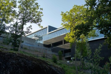 Modern glass building with green scenery surrounding