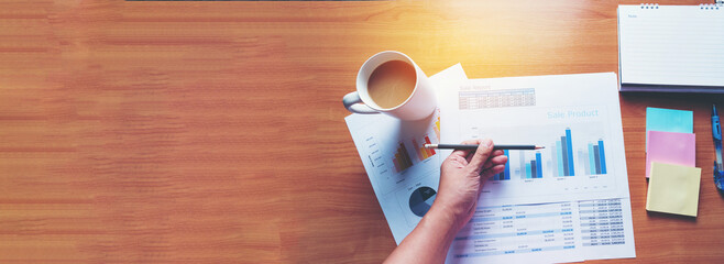 Banner woman working office desk reading financial report finance chart graph on table. Wide tax...
