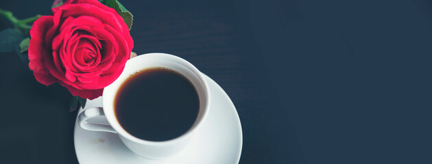 Banner Tabletop black coffee cup red rose on wood table with empty background. Espresso shot...