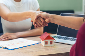 Close up Businesswoman shakes hands customer dealing real estate house agent signing contract. Diversity women agent hands office desk. Crop Women handshake sign on insurance mortgage sale document - obrazy, fototapety, plakaty