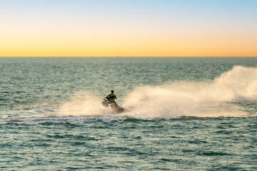 Jet skiing in Darwin harbour at sunset, Northern Territory.