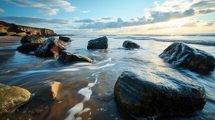 Rocks and pebbles on a beach. Surf water motion with longtime exposure showing flowing streams and rivulets. Low contrasting evening sun light.