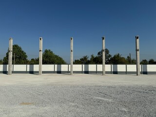 Construction of a roof structure for a large parking lot Set up the structural pillars in a pattern.