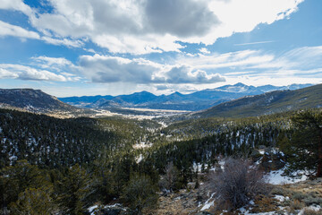 Fototapeta premium wide angle view of mountain range with valley in the foreground with clouds in the winter