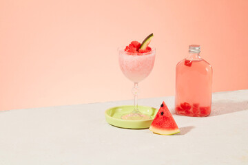A watermelon smoothie, fresh watermelon slices and a transparent bottle of detox water on a pastel background. Empty space for text design. Advertising.