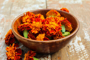 Red marigold flowers in a wooden bowl 