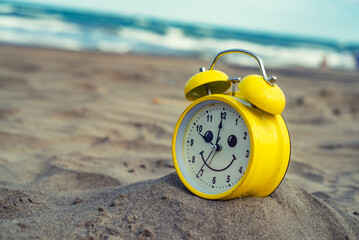 yellow clock on the beach vacation fun time