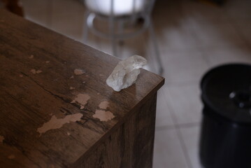 Pedra quartzo branco em cima da mesa de madeira no quarto a luz do dia