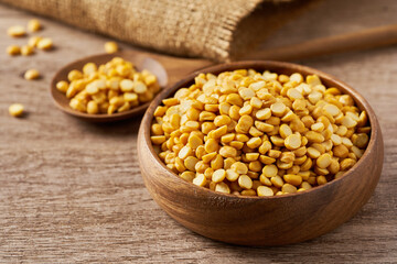 pile of split bengal gram or chana dal in wood bowl on wood table rustic food background