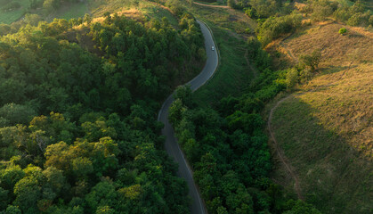 Aerial view of road dark green forest Natural landscape and elevated traffic roads Adventure travel and transportation ideas for the environment	
