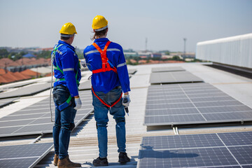 Technicians are inspecting standards of solar panels on roof of an industrial factory. Electrical...