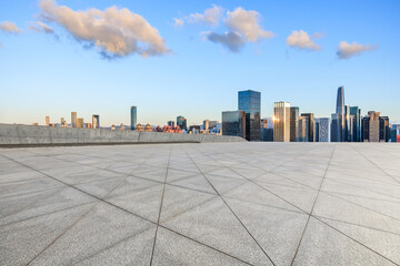 Empty square floor and city skyline with modern buildings under blue sky