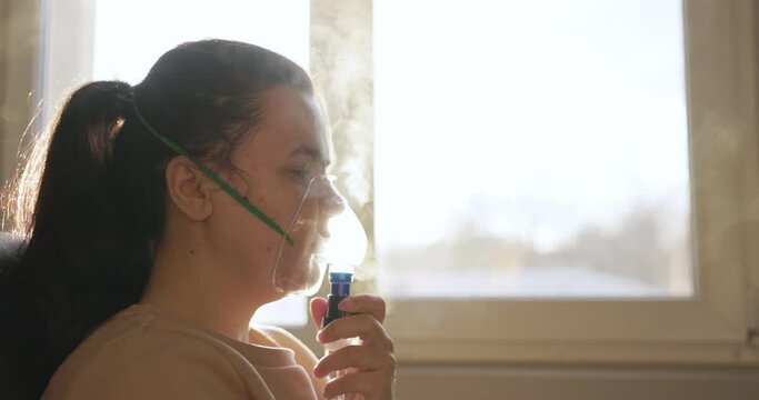 Sick Woman Inhaling Mist From Nebulizer Mask - Treatment For Respiratory Diseases. - side view, close up shot