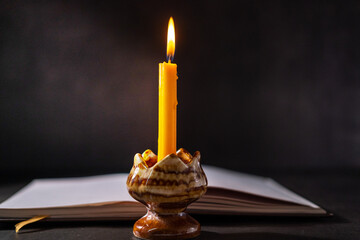 Yellow candlestick gives light while reading, black background