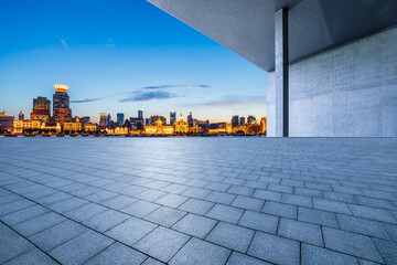 Empty square floor and wall with city skyline at night in Shanghai