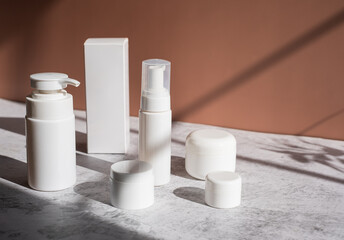 Mockup cosmetic packaging on brown background in rays of sunlight. beauty and skincare concept