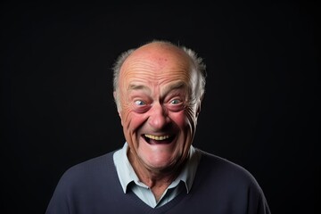 Senior man with funny expressions on a black background. Studio shot.