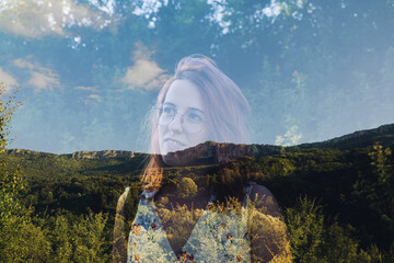 Double exposure of a woman in the forest and mountains