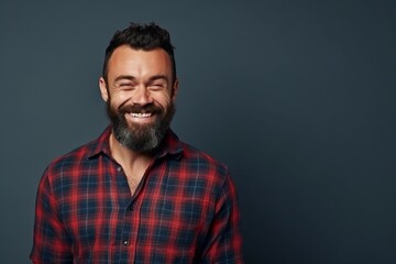 Portrait of a handsome man in checkered shirt over grey background.